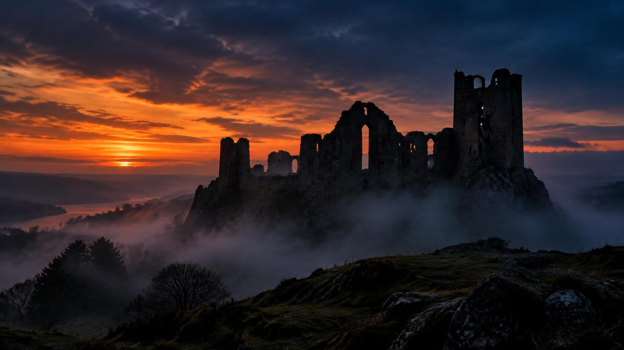 Silhouette of an old stone castle at dusk with dramatic sky